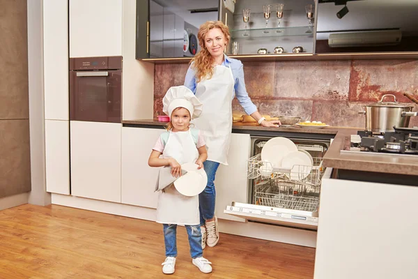 Funny daughter and her mother cook dinner together. Happy family. Healthy eating.