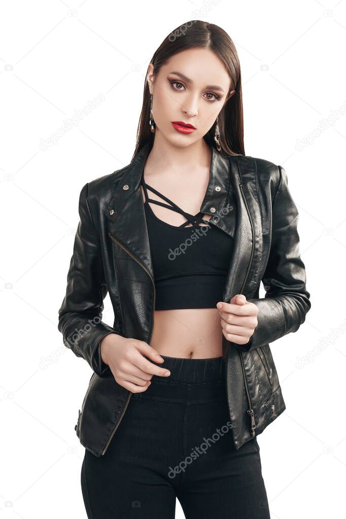 Fashion shot. Portrait of a beautiful brunette girl posing in black clothes on a gray background. Studio shot.