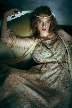 Vintage koltukta oturan güzel kızıl saçlı genç bir kadının portresi. Hippi tarzı. Bohem stili.