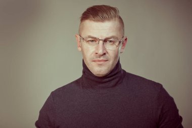 Gri arka planda zarif gözlüklü, ciddi bir olgun adamın portresi. İş adamı portresi. Uzayı kopyala Stüdyo çekimi.