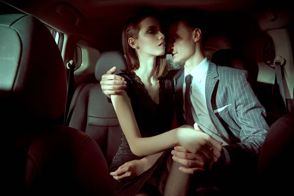 Glamorous passionate couple in a car. Beauty, fashion.