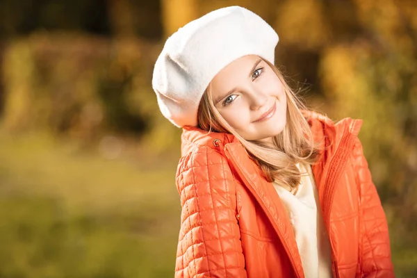 A cute fair-haired girl in clothes on autumn clothes countryside. Beauty, autumn fashion.