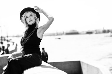 Nehir kenarındaki zarif, yaşlı bir kadının portresi. Güzellik, moda.