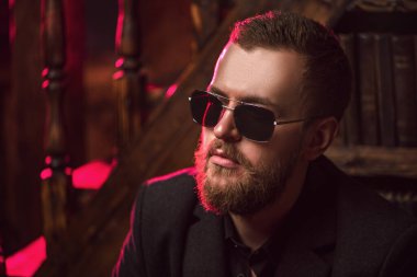 Güneş gözlüğü takan şık bir adamın yakın plan portresi. Erkekler için güzellik ve tarz.