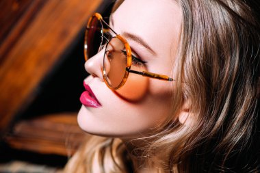 Güneş gözlüğü takan kendine güvenen bir kadının yakın portresi. Güzellik, makyaj, tarz.