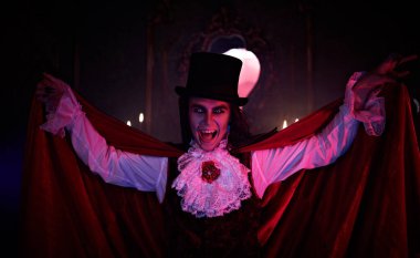 Kana susamış vampir eski bir ortaçağ şatosunda gece dişlerini gösterdi. Geleneksel vampir adam. Cadılar Bayramı.