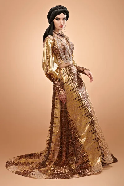 Oriental beauty woman. Full length portrait of a beautiful arabian woman in traditional dress, with traditional oriental make-up and black hijab. Make-up and cosmetics. Studio shot.
