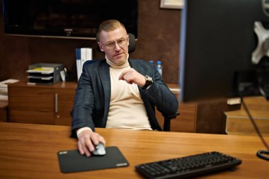 Takım elbiseli ve gözlüklü saygıdeğer orta yaşlı işadamı modern bir ofiste çalışıyor. Başarılı yönetici kavramı.