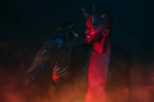A portrait of a bad demon with a black raven. Horror movie, nightmare. Halloween.