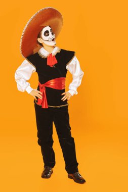 Parlak sarı arka planda şeker kafalı yakışıklı bir çocuğun portresi. Cadılar Bayramı. Dia de los muertos. Ölüler günü. Uzayı kopyala Tam boy portre.