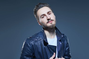 Erkek modası. Siyah deri ceketli yakışıklı bir adamın portresi. Stüdyo resmi. 