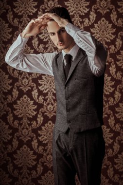 Zarif klasik takım elbiseli yakışıklı bir adamın portresi ve klasik bir arka planda kravat. İş stili. Erkek modası.