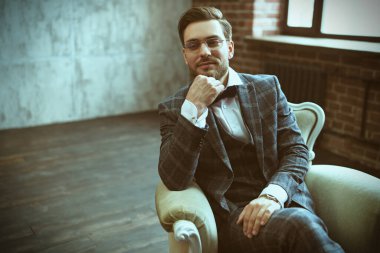 Şık takım elbiseli yakışıklı bir adamın portresi koltukta rahatça oturup gülümsüyor. Başarılı bir iş adamı. Hayat güzel bir kavram.. 