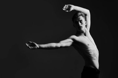 Mükemmel kaslı vücudu olan yakışıklı bir genç adamın siyah-beyaz portresi. Erkek güzelliği ve sağlığı. Spor ve vücut geliştirme. 