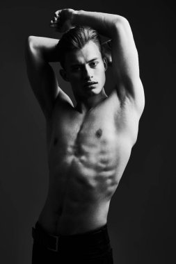Mükemmel kaslı vücudu olan yakışıklı bir genç adamın siyah-beyaz portresi. Erkek güzelliği ve sağlığı. Spor ve vücut geliştirme. 