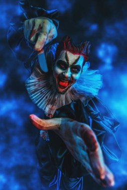 Korku filminden bir bıçakla kızgın deli bir palyaçonun portresi. Cadılar Bayramı, karnaval.