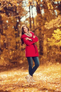 Sonbahar ormanındaki güzel bir genç kadının uzun bir portresi. Yaşam tarzı, sonbahar modası, güzellik. 