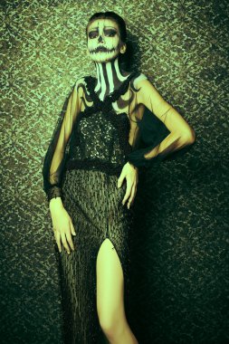 Kaliteli arka planda kafatası kabağı makyajı olan zarif bir bayan. Eski tarz. Cadılar Bayramı. Ölülerin Günü. 