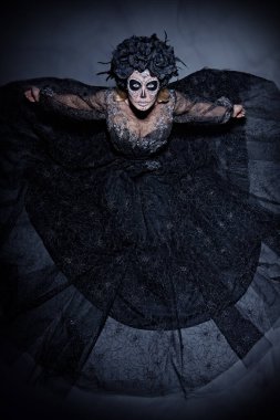 Korkunç ve güzel Calavera Catrina karanlık arka plandan kameraya bakıyor. Kafatası şekeri makyajlı manken. Dia de los muertos. Ölüler Günü. Cadılar Bayramı.
