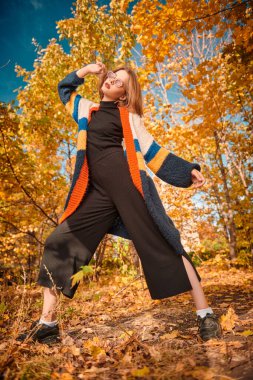 Güzel modern kız sonbahar parkında poz veriyor. Mevsimlik stil, sonbahar güzelliği, moda.