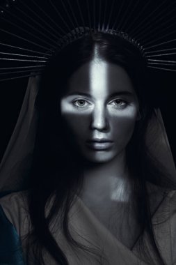 Karanlık bir arka planda, ışık ışınlarıyla birlikte Meryem Ana 'nın tek renkli portresi. Modern din sanatı. Vaftiz töreni..