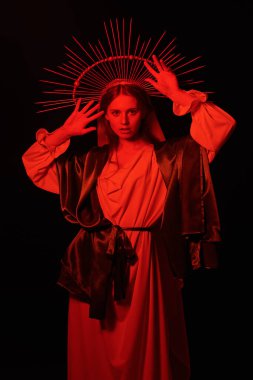 Siyah arka planda kırmızı ışıkta duran Bakire Meryem portresi. Modern din sanatı. 