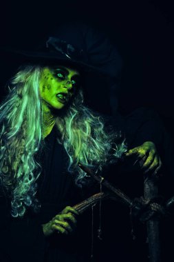 Yüzü çirkin, elleri sopalı, gri saçlı, korkunç cadılar bayramı cadısının portresi. Korkunç hikayeler..