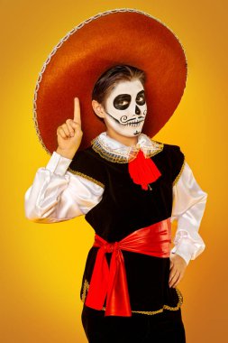 Parlak sarı arka planda şeker kafalı yakışıklı bir çocuğun portresi. Cadılar Bayramı. Dia de los muertos. Ölüler günü. Boşluğu kopyala.