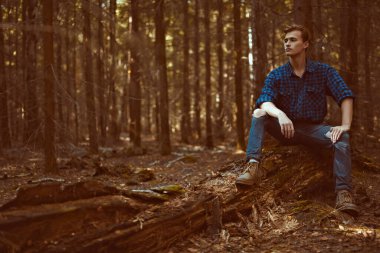 Vahşi ormanda yakışıklı, erkeksi bir adam. Macera, özgürlük ruhu. Etkin yaşam biçimi. 