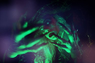 Yeşil ışıkta korkunç çirkin cadının portresini kapat. Cadılar Bayramı. Korkunç hikayeler.. 