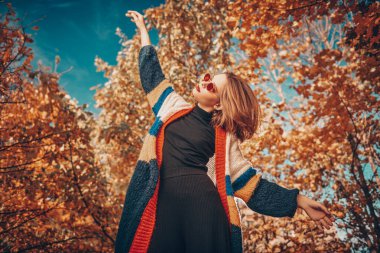 Güzel modern kız sonbahar parkında poz veriyor. Mevsimlik stil, sonbahar güzelliği, moda.