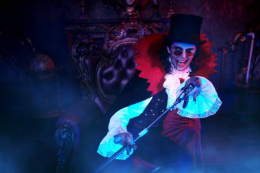 Eski kalesinde gecenin bir yarısı elinde mikrofonla oturan ilahi söyleyen vampir dişlerini gösterdi. Kont Drakula. Cadılar Bayramı.