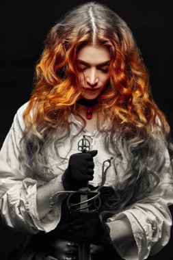 A redhead woman with a war sword (rapier) prays while holding a sword . The heroine of a historical adventure novel. clipart