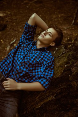 Adam ormanda bir çıkmazda yatıyor ve dikkatle kafasını kaldırıyor..