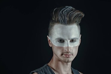 Siyah arka planda beyaz boyalı yakışıklı bir gencin sanat portresi. Erkek güzeli, moda. Saç stili ve kozmetik.