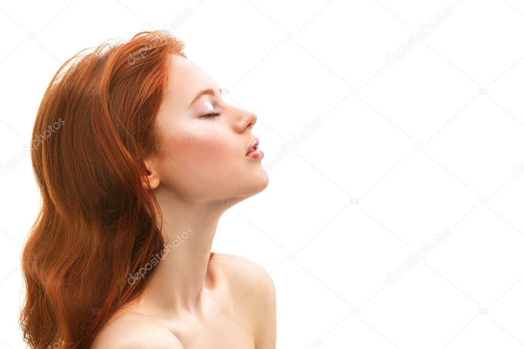 Portrait of a beautiful young woman with magnificent red hair and freckles on her face. Beauty and skin care. White background with copy space.