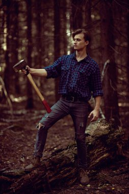 Vahşi ormanda baltası olan yakışıklı, güçlü bir oduncunun tam boy portresi.. 