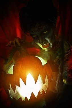 Cadılar Bayramı konsepti Gizemli kabak kafalı feneriyle korkunç bir genç çocuğun portresi.. 