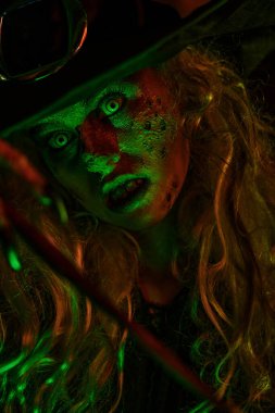 Yeşil ve kırmızı ışıktaki korkunç çirkin cadının portresini kapat. Cadılar Bayramı. Korkunç hikayeler.. 