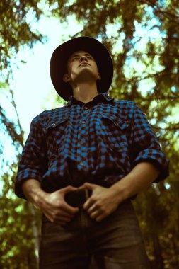 Vahşi ormanda yakışıklı, erkeksi bir adam. Macera, özgürlük ruhu. Etkin yaşam biçimi. 