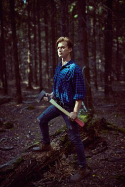 Vahşi ormanda baltası olan yakışıklı, güçlü bir oduncunun tam boy portresi.. 