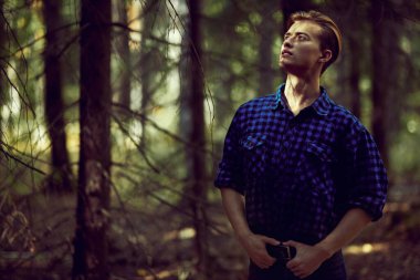 Vahşi ormanda yakışıklı, erkeksi bir adam. Macera, özgürlük ruhu. Etkin yaşam biçimi. 