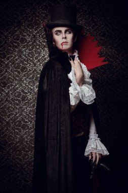 19. yüzyılın geleneksel aristokrat vampirinin portresi zarif bir takım elbise içinde ve dudaklarında bir damla kan ile. Cadılar Bayramı.