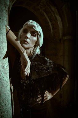 Güzel gri saçları ve mezarlıktaki bir mahzende poz veren zengin siyah elbisesi olan aristokrat bir dul kadın. Kara Dul. Gizemciliğin atmosferi. Cadılar Bayramı.