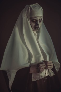 Korku ve Cadılar Bayramı. Korkunç şeytani bir rahibenin portresi kanlı gözleriyle siyah bir arka planda kameraya bakıyor.. 