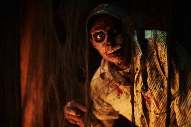 Yıkık bir binada korkunç kana susamış zombi adam. Dehşet. Cadılar Bayramı.