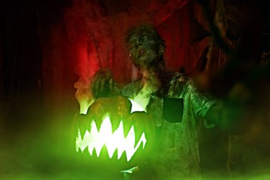 Cadılar Bayramı konsepti Gizemli kabak kafalı feneriyle korkunç bir genç çocuğun portresi.. 