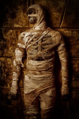 Cadılar Bayramı mumyası yıkılmış duvarın arkasında poz veriyor. Cadılar Bayramı. Antik Mısır mitolojisi.