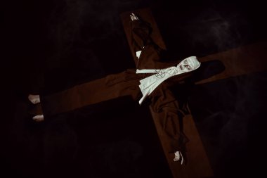 Portrait of scary devilish nun in a dark room in light in the form of a cross. Horrors and Halloween. clipart