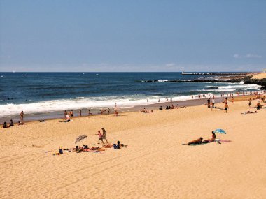 gündüz kumlu sahilde dinlenen turistlerin görünümü  